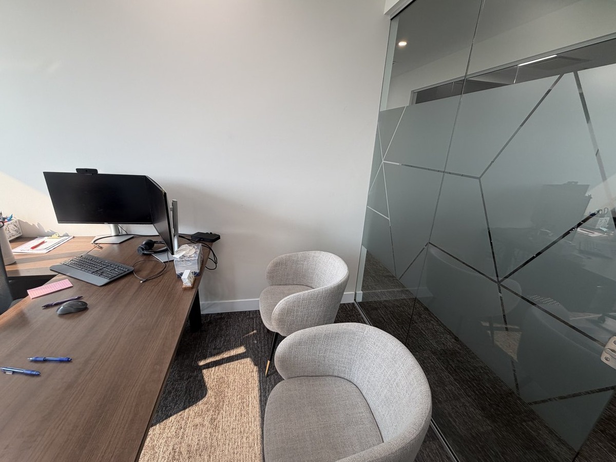 Office 4 desk with visitor chairs beside the glass wall